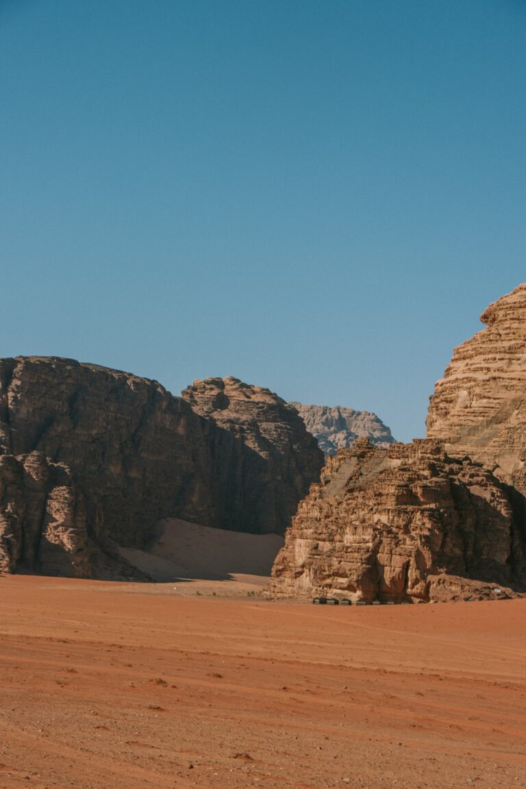a desert landscape with rocks and a mountain in the background