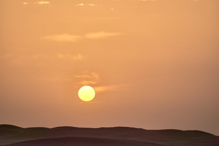 a sunset over a hill
