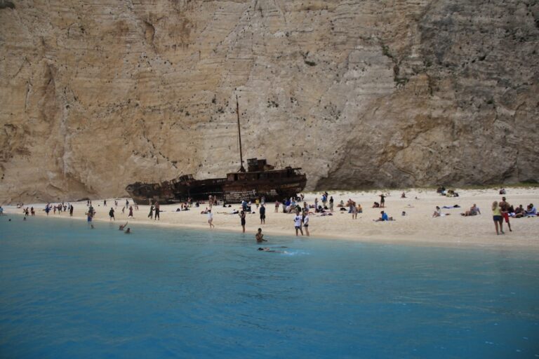 a group of people standing on top of a sandy beach