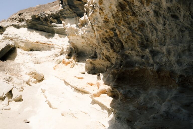 a person climbing up a mountain side with a sky background