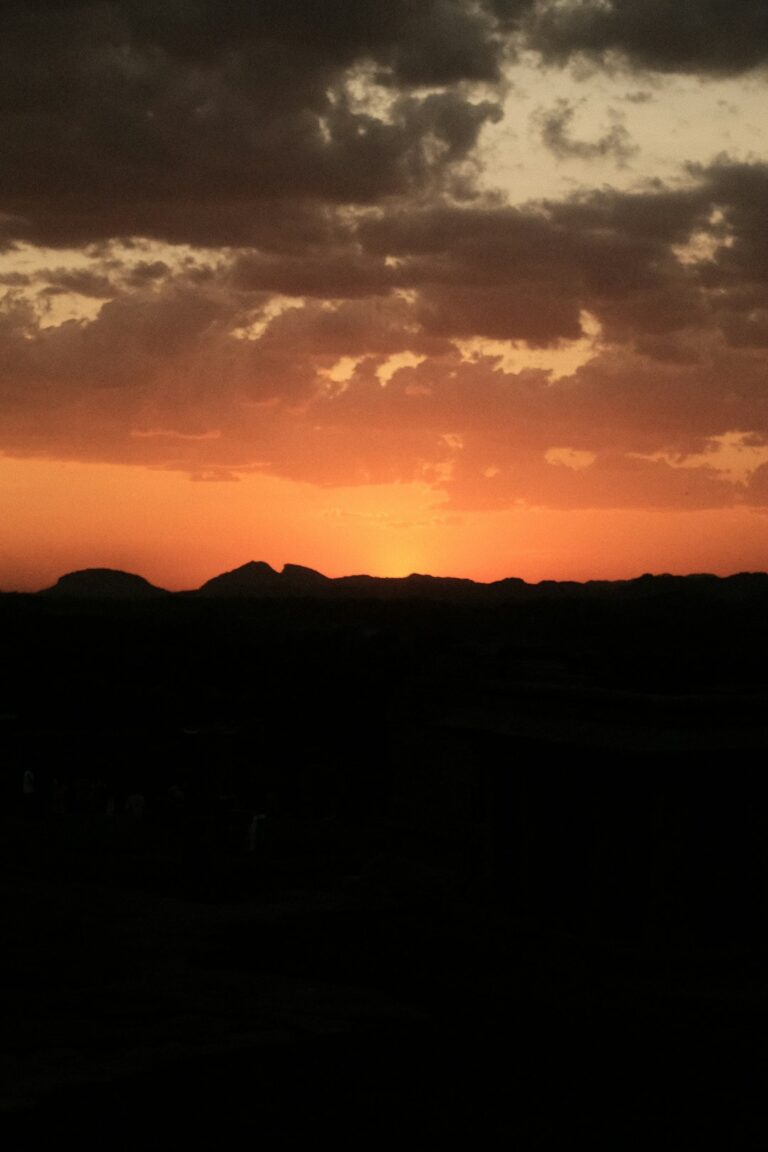 the sun is setting over a mountain range