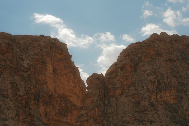 a large rock formation with a sky in the background