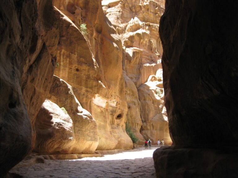 a narrow canyon with people walking through it