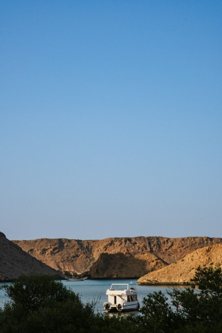 a white boat floating on top of a body of water