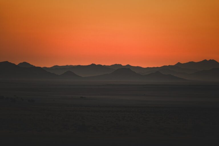 The sun is setting over the mountains in the desert