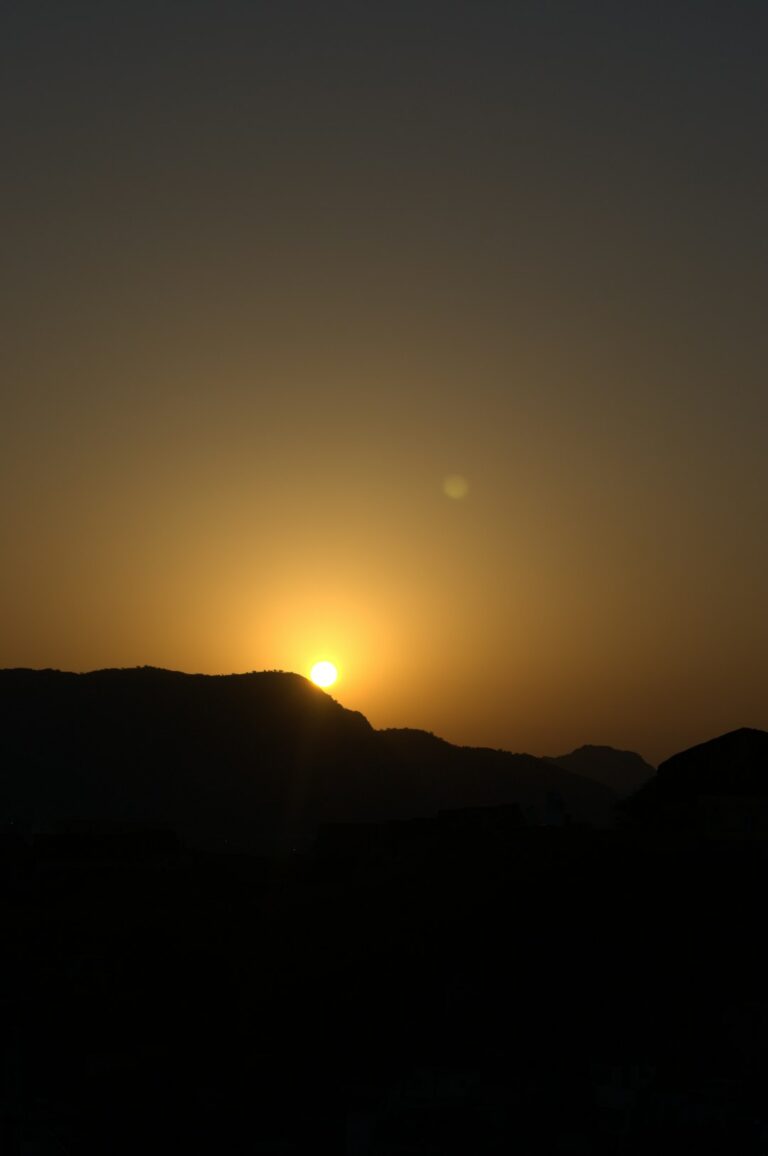 The sun is setting over a mountain range