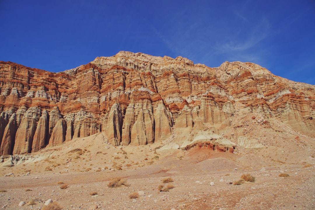 A rocky mountain with a blue sky in the background