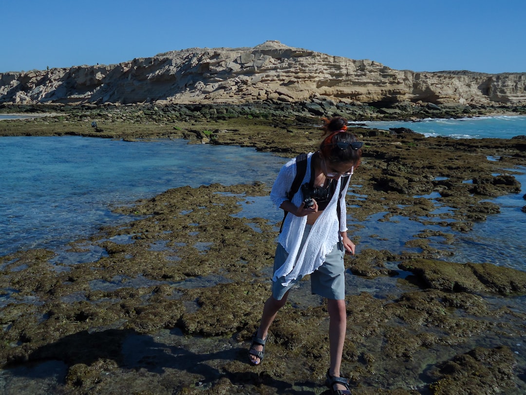 A person explores a rocky seashore.
